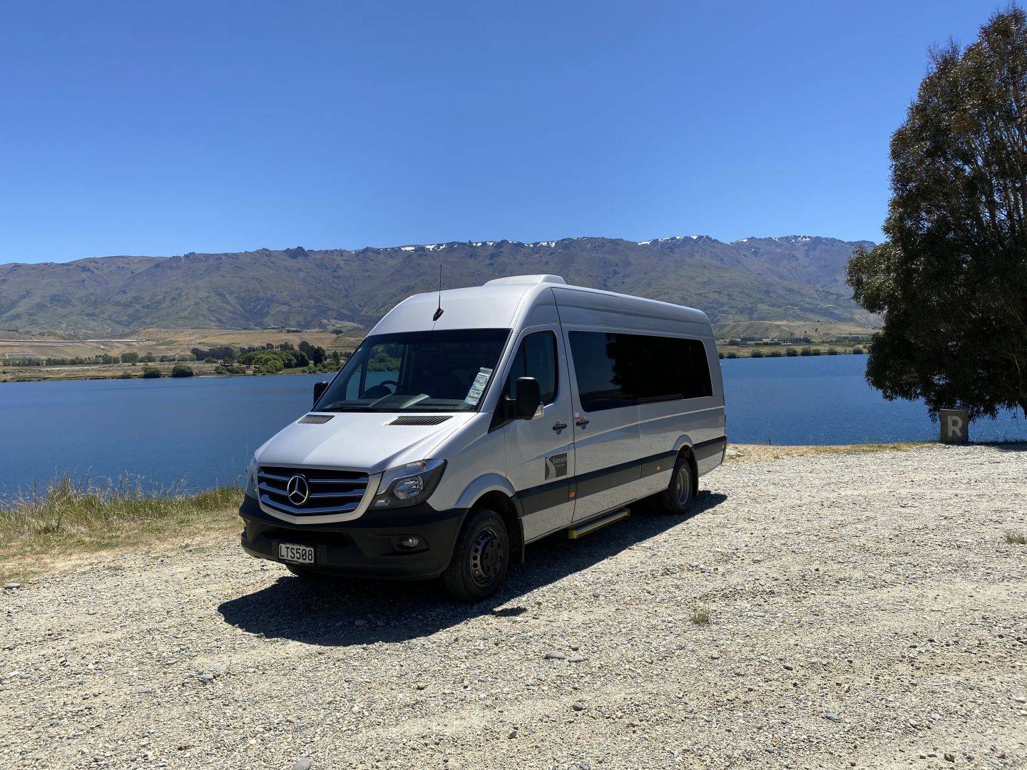 Charter van in fornt of lake